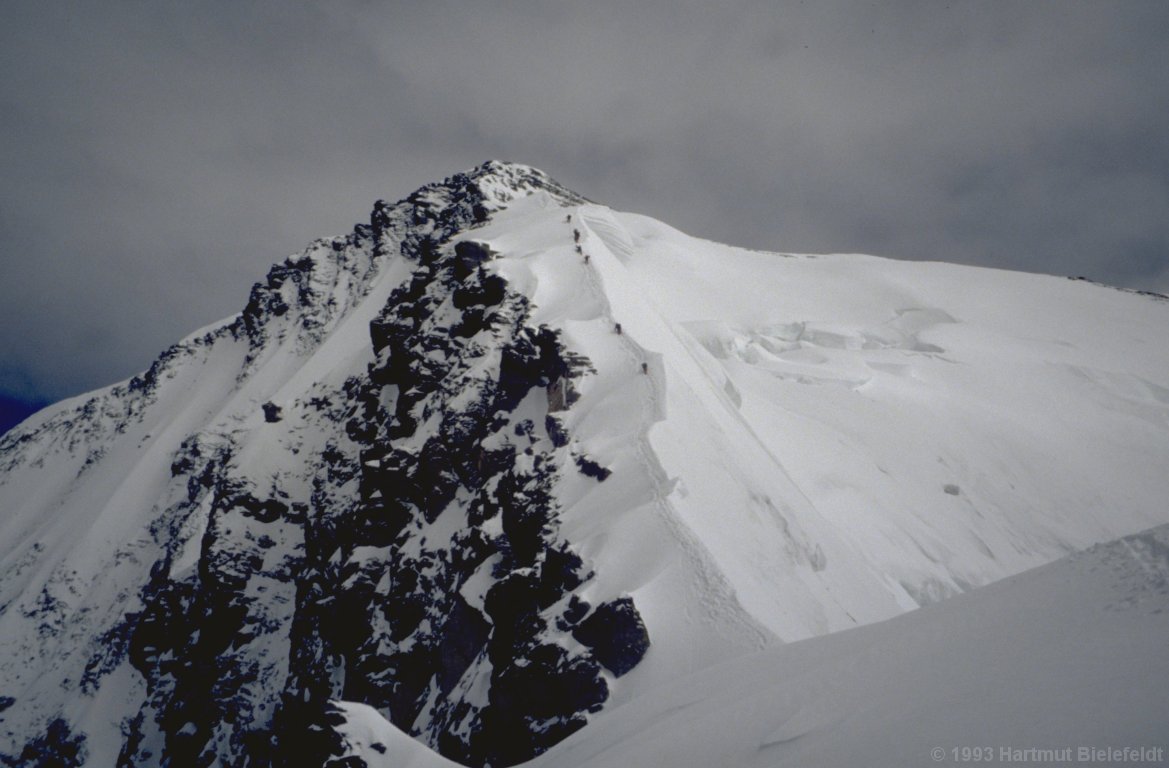 Das Bild täuscht: Die vorderen Bergsteiger müssen vor dem Gipfel noch durch eine Mulde