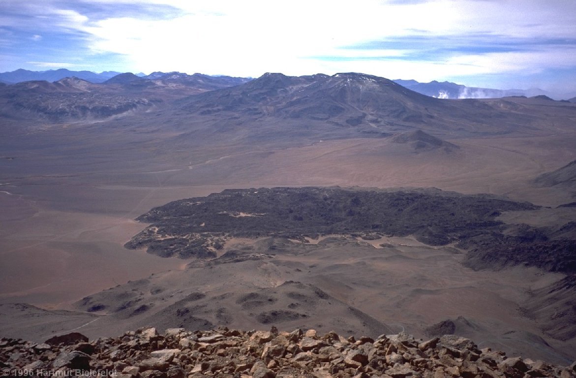 Auf dem Gipfel des Cerro Colorado (5748 m): Hinten dampfen die Tatio-Geysire, unter uns ein altes Lavafeld.
