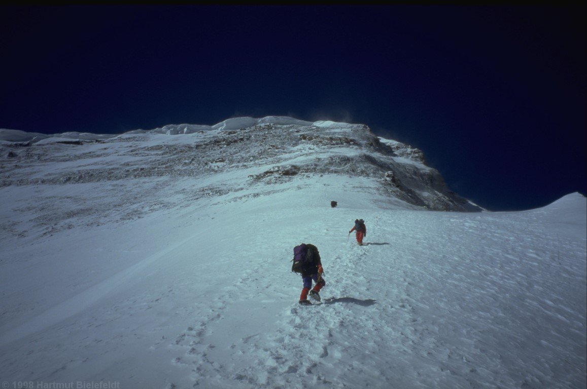 Die Schneeflanke mündet in eine steile Felswand.