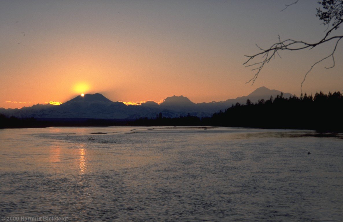 The sun is setting behind Mount Foraker. Right side: Hunter and Denali.