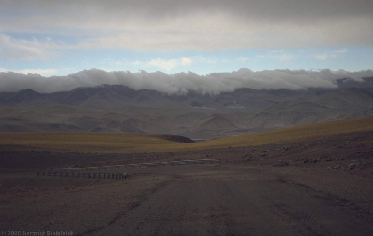 Auf der argentinischen Seite drücken die Wolken über die niedrigeren Berge