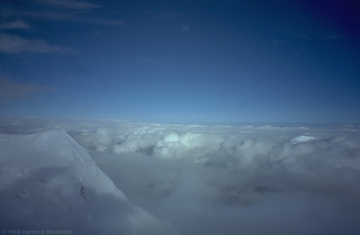 Bald kommen wir aus den Wolken heraus und können auf den Tschapajev Nord hinunterschauen.