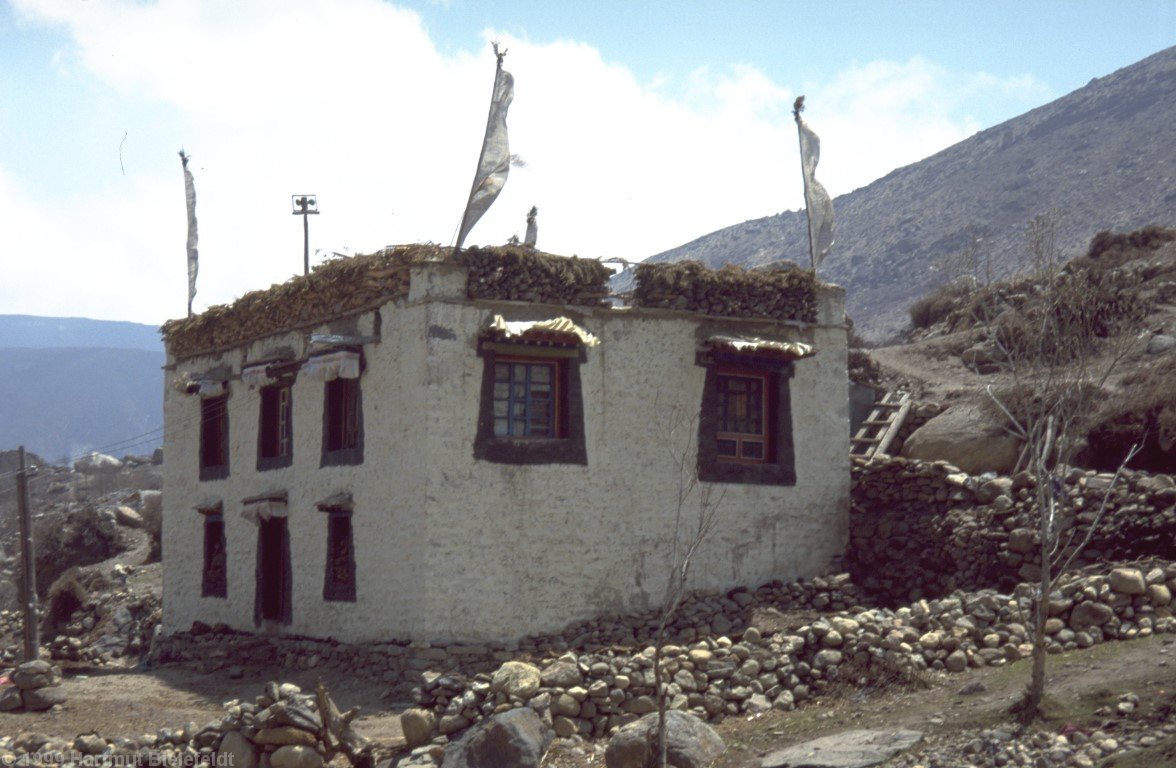 Tibetisches Haus in Nyalam. Holz ist auf dem Dach gelagert.
