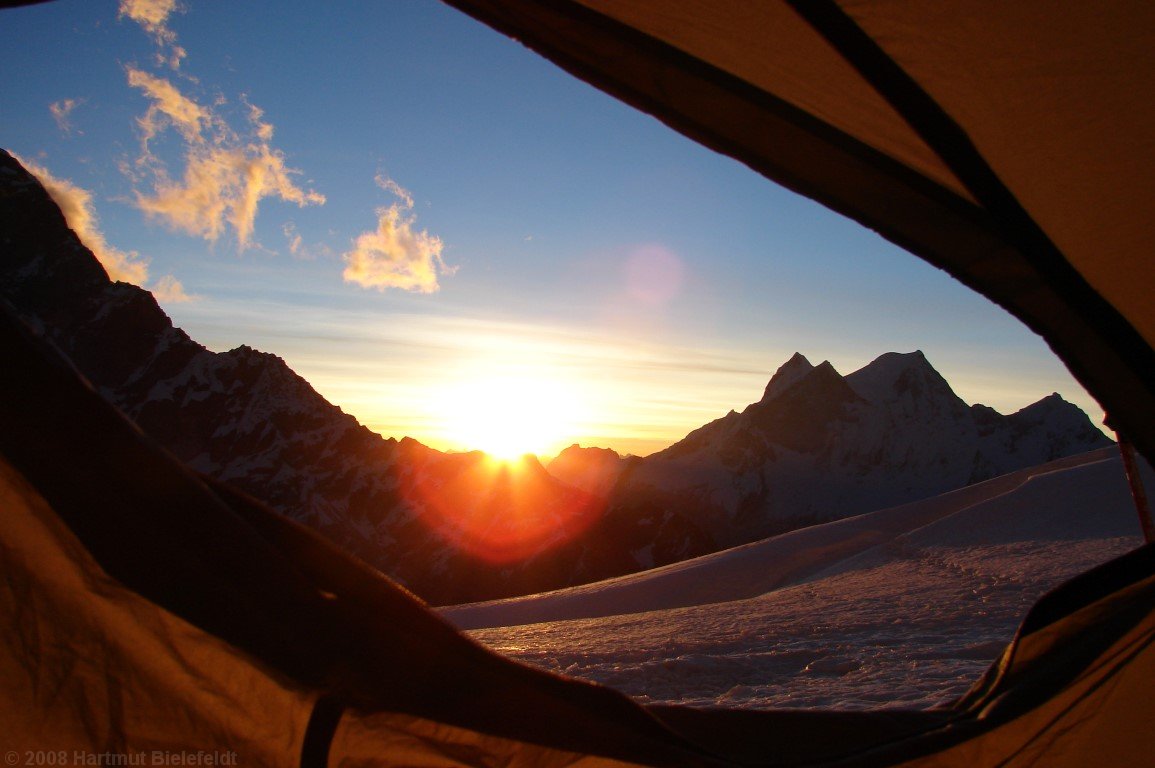 The sun sets next to the Huandoys